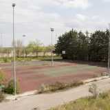 Il viale d�ingresso ci porta subito davanti ai desertici campi sportivi, privati di tutto i loro elementi caratteristici: in quello da tennis non rimane pi� alcuna traccia della rete, su quelli da calcio sono state portate via le porte...